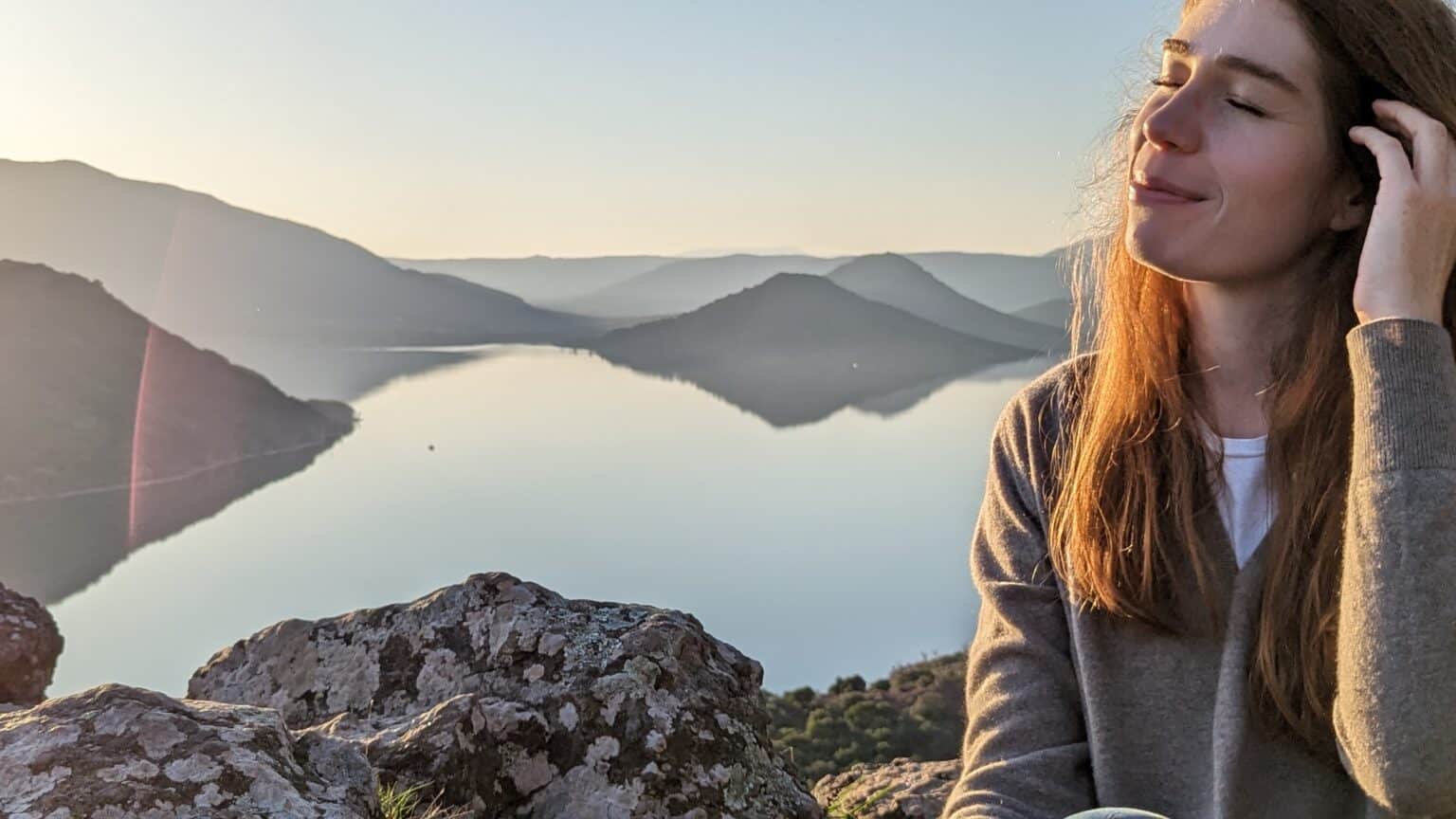 Elise Rouvrais, naturopathe à Lunel, au bord d’un lac au soleil couchant